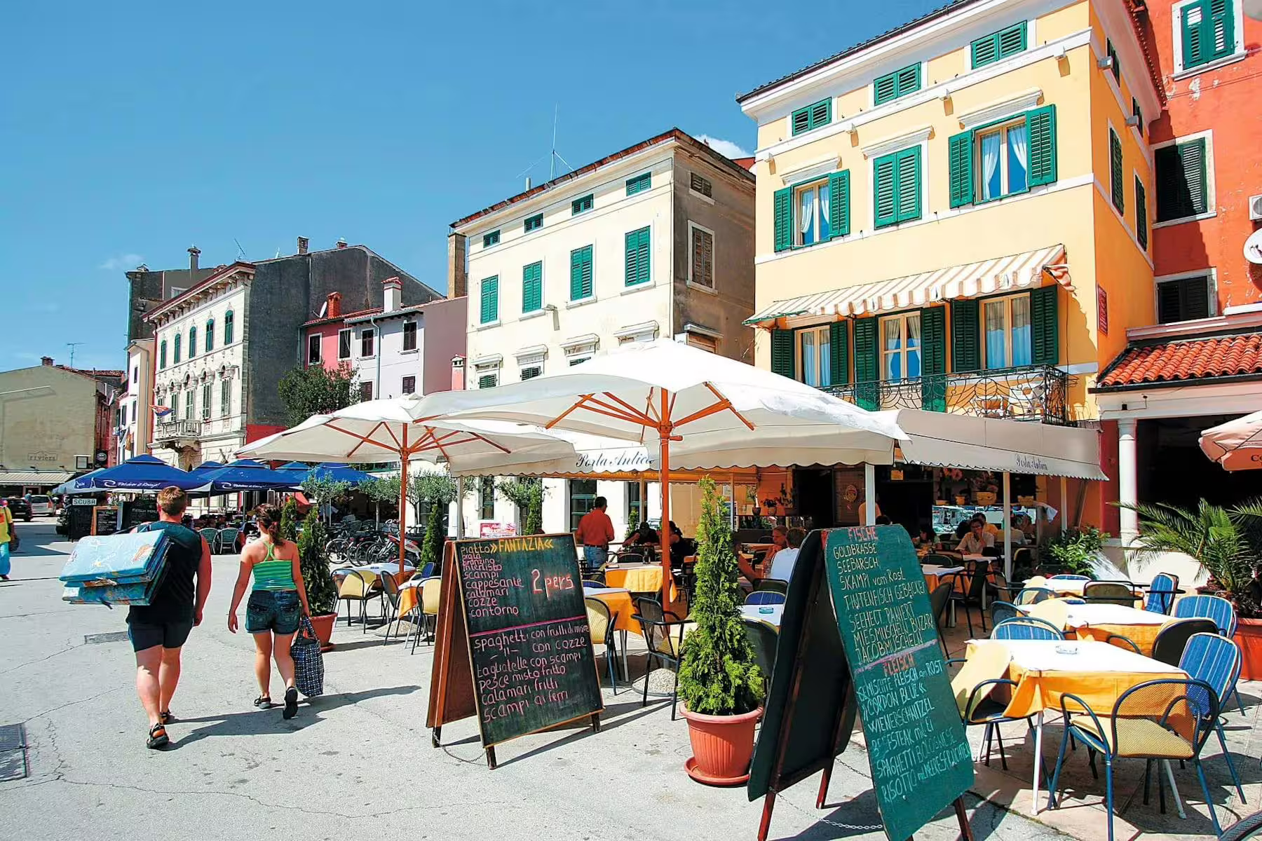 Colorful Poreč waterfront cafés and old town facades, a highlight of the Istrian Coast boat cruise with BBQ