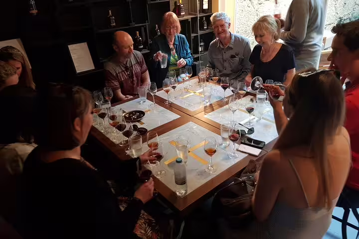 Group enjoying a Port and Douro wine tasting session around a cozy table with multiple wine glasses.