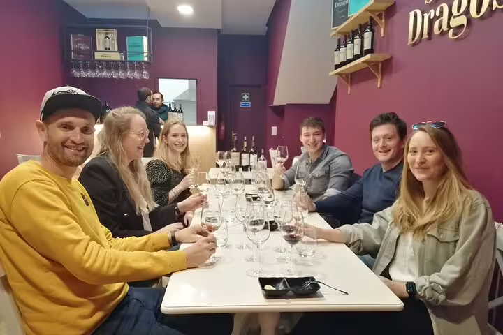 Group enjoying Port and Douro wine tasting at a cozy venue, highlighting the social aspect of the 3-hour tour.