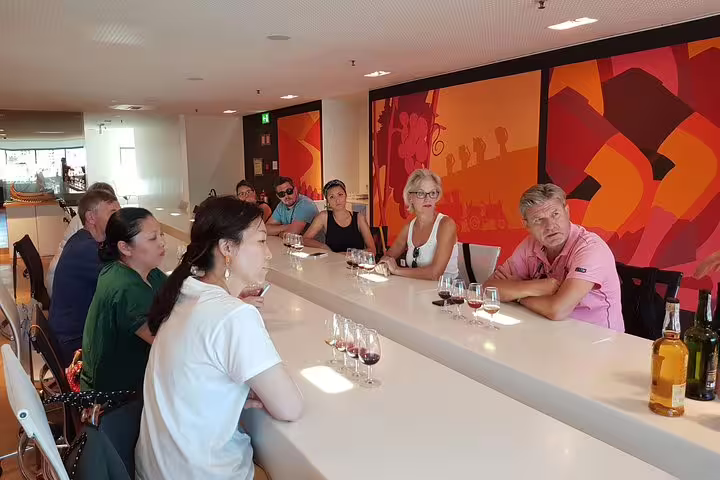 Tour participants attentively listening during a Port and Douro wine tasting session, showcasing an engaging experience.