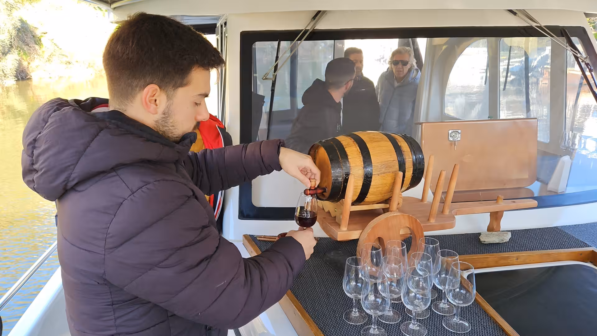 Pouring port wine from a barrel on a Douro River boat cruise, part of Douro Valley tour with wine tasting