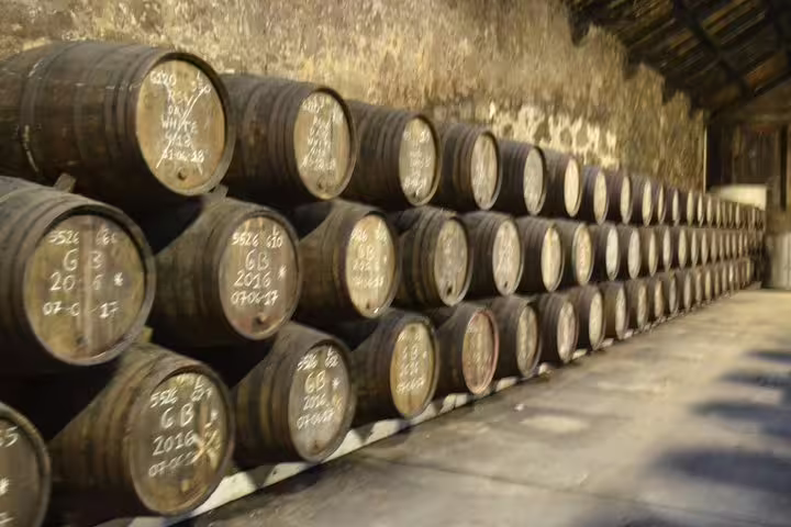 Rows of oak barrels aging Port wine in a traditional Douro Valley wine cellar.