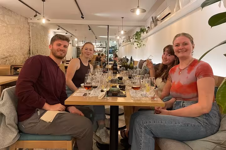 Guests enjoy curated flights of five Port wines with cheese pairings, guided by a sommelier in a stylish Porto bar