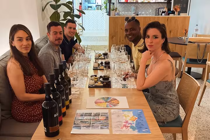 Small-group Port wine tasting with a sommelier, guests seated around bottles and tasting wheel, explore Douro Valley flavors