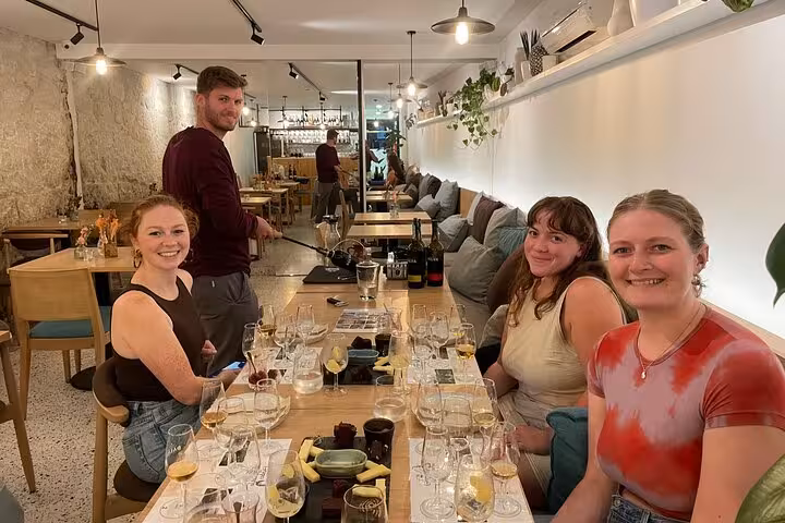 Friends sample five Douro Valley Port wines during a sommelier-led tasting in a bright, plant-filled wine lounge in Porto