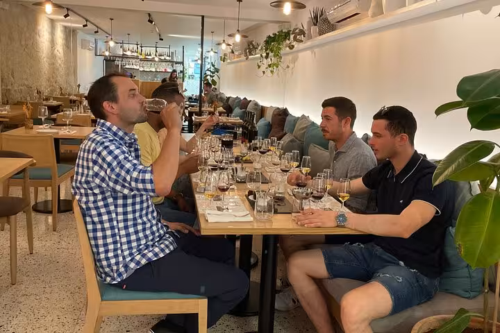 Guests sample a five-Port flight in a cozy Porto wine bar, guided by a sommelier with tasting notes and food pairings.