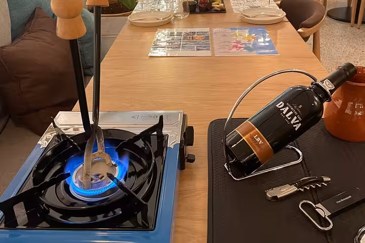 Sommelier-led Port wine tasting setup with LBV Dalva bottle, corkscrew, and heated port tongs for decanting ritual.