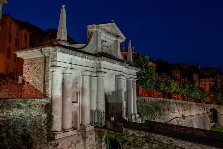 Night view of Porta San Giacomo in Bergamo Città Alta, a scenic stop on the self-guided scavenger hunt tour