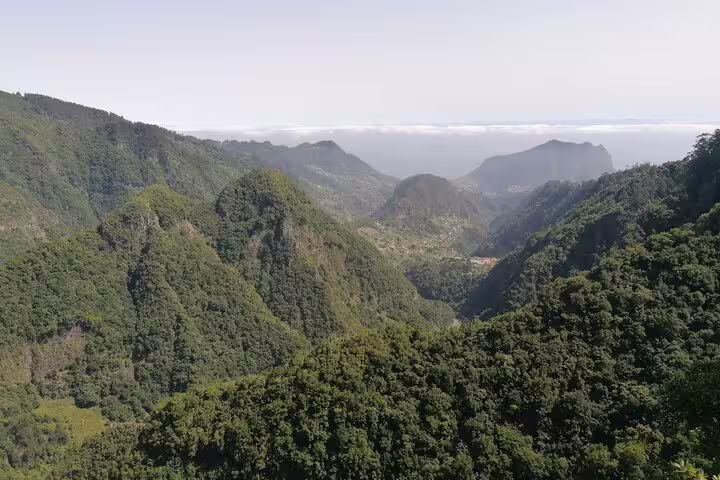 Breathtaking mountain views from Portela, Madeira showcasing lush green peaks and valleys under a clear sky.