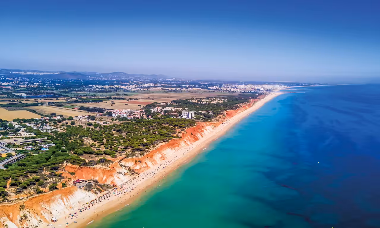Aerial view of Portimao Algarve stunning red-cliff beach and turquoise sea perfect for a sunset experience tour