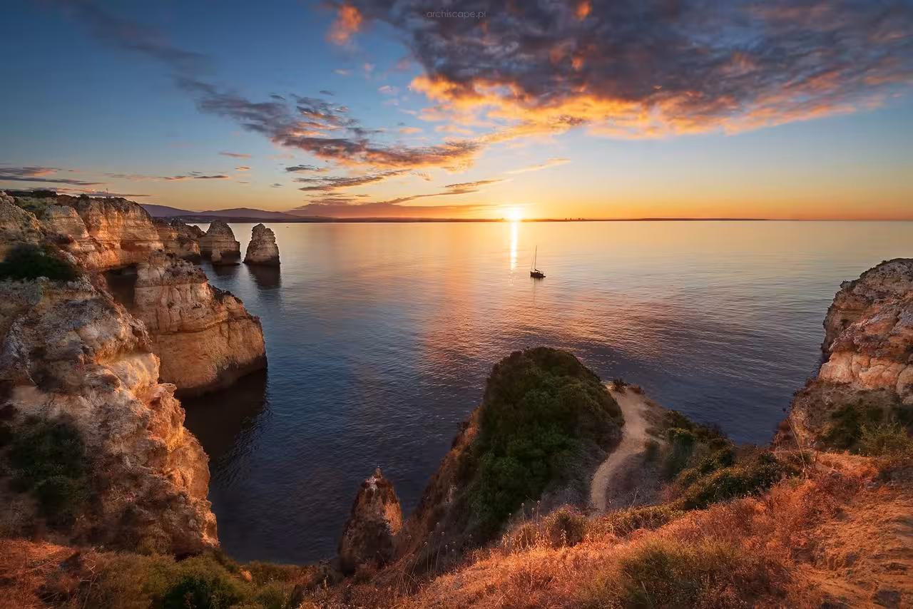 Panoramic Ponta da Piedade sunset view from Lagos with sea stacks and calm water, perfect for a sunset cruise