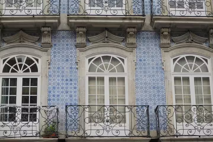 Ornate building facade in Porto featuring traditional blue azulejos tiles, ideal for a cultural wine and cheese tour.