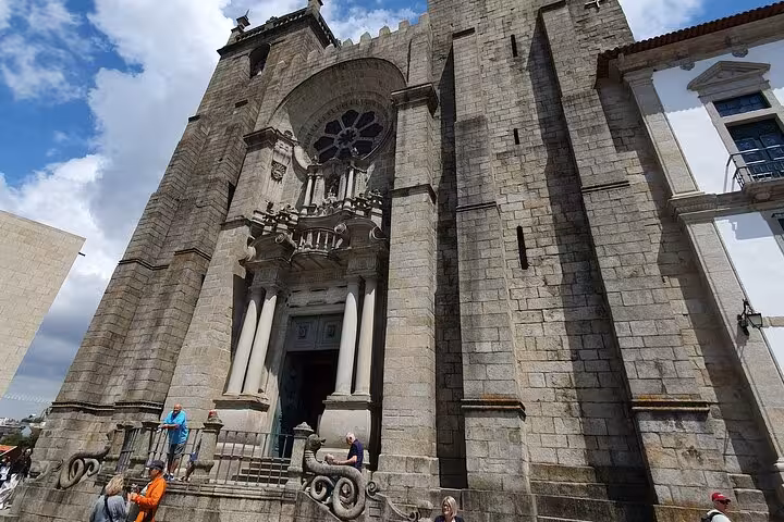 Front view of Porto Cathedral's Gothic architecture under a bright sky, highlighting its historical significance.