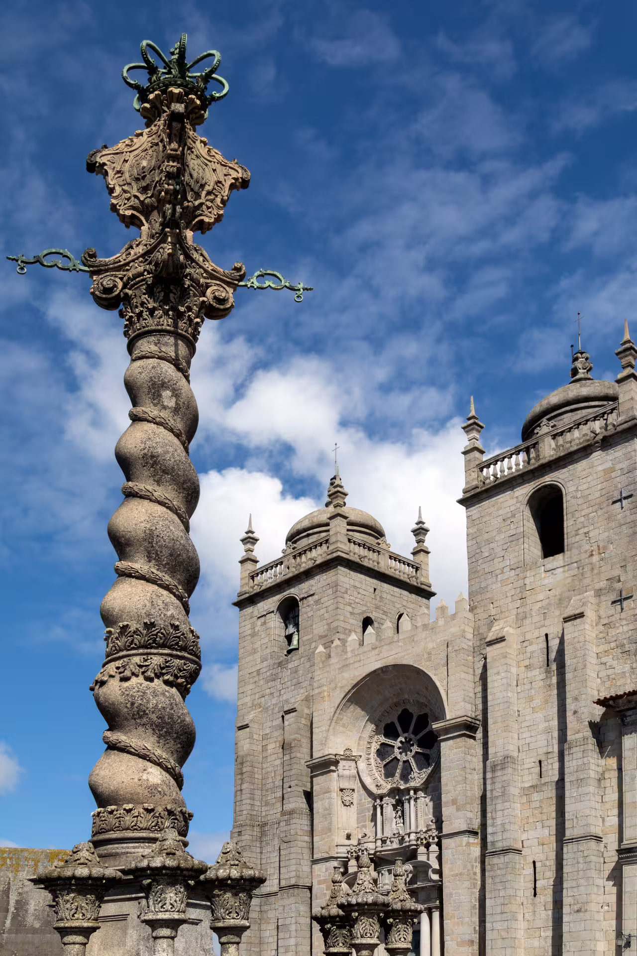 Historic Porto Cathedral and ornate column against a bright blue sky, featured in our small-group Porto walking tour.