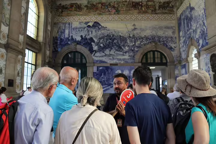 Tour group exploring São Bento Station's iconic blue tile murals in Porto on a private city tour.