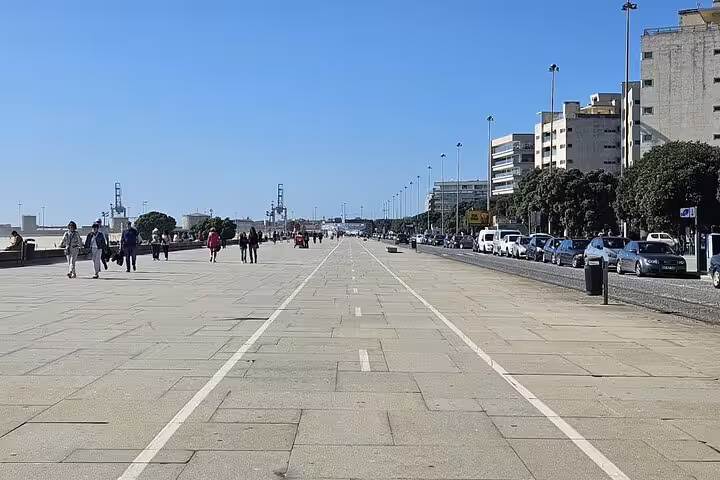 Promenade view in Porto with people walking along the coastal path under a clear blue sky, perfect for a private city tour.