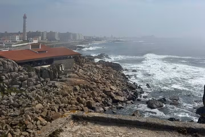 Rocky Porto coastline and lighthouse with ocean waves, featured on half-day Porto & beach-side small-group tasting tour