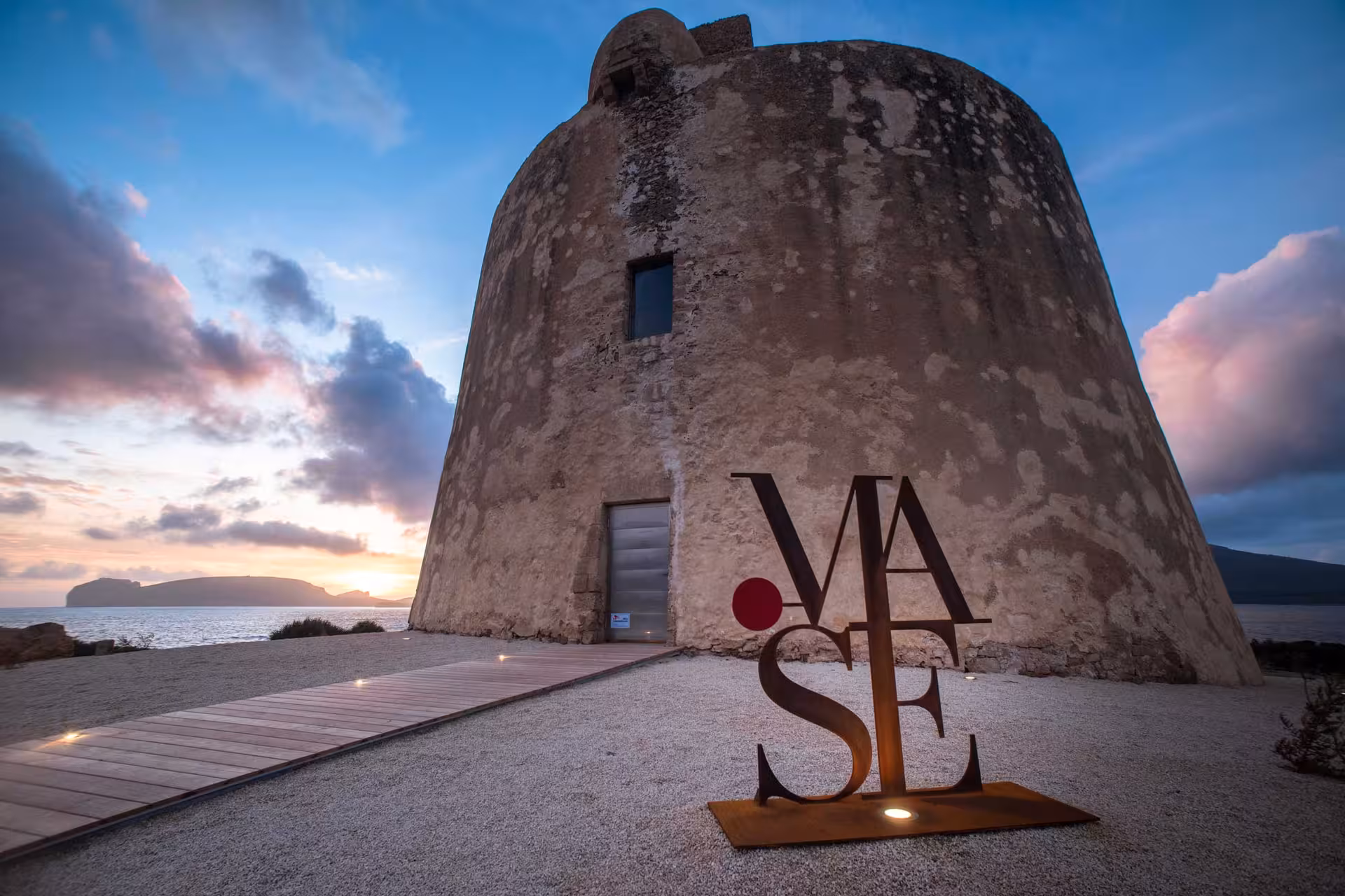 Historical tower at Porto Conte Park Ecomuseum in Alghero set against a stunning sunset, perfect for cultural exploration.