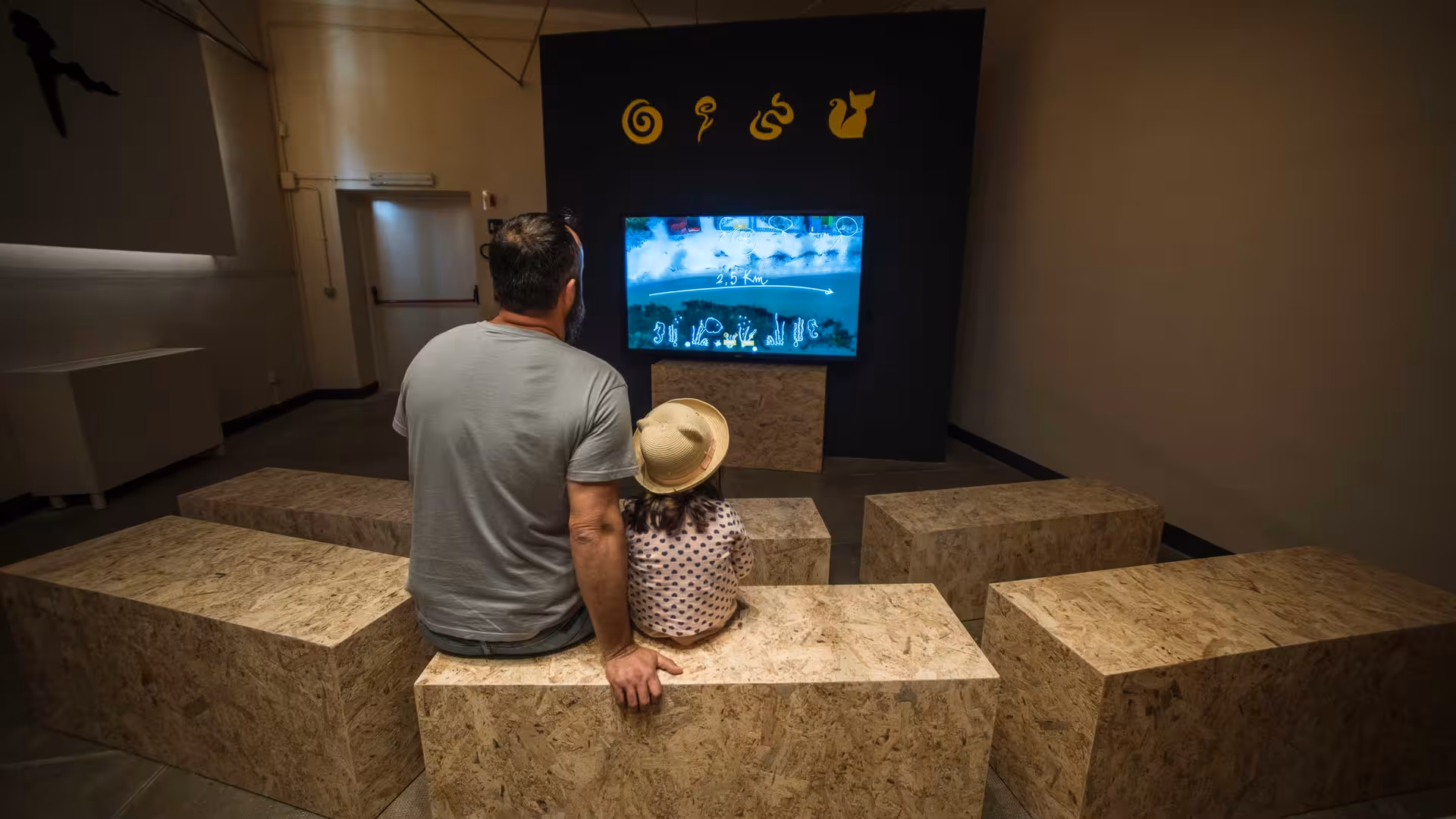 Father and daughter watching an educational display at Porto Conte Park Ecomuseum in Alghero.