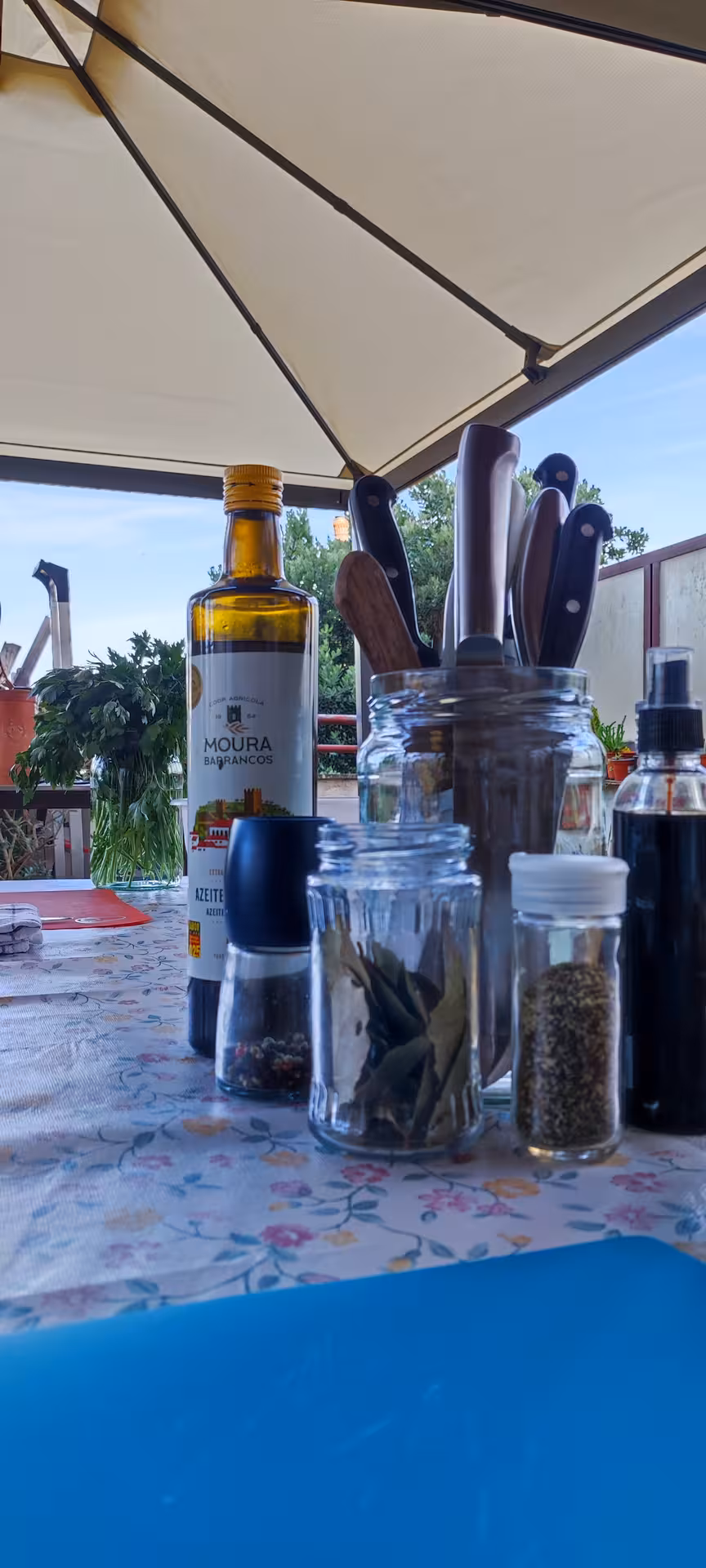 Outdoor table setup with olive oil, spices, and knives ready for a Porto cooking class with Jorge and Isabel.