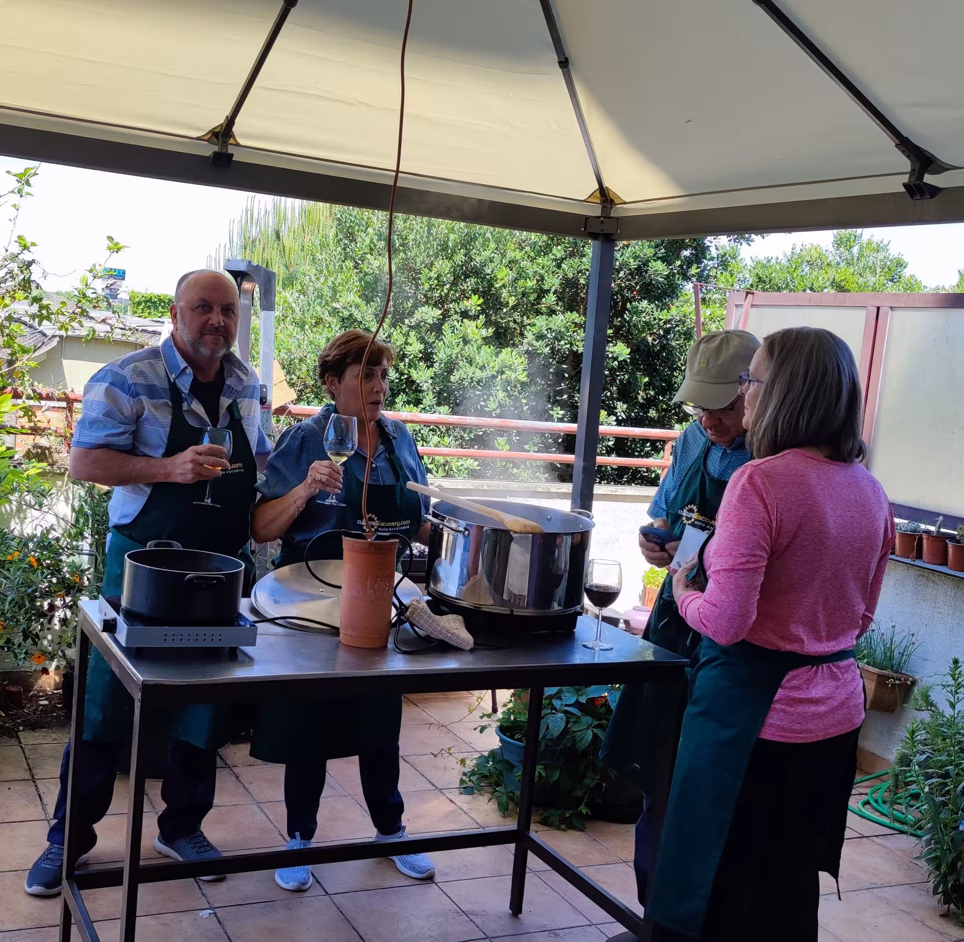 Guests enjoy wine and conversation during the Porto Cooking Class with Jorge and Isabel under a cozy outdoor canopy.