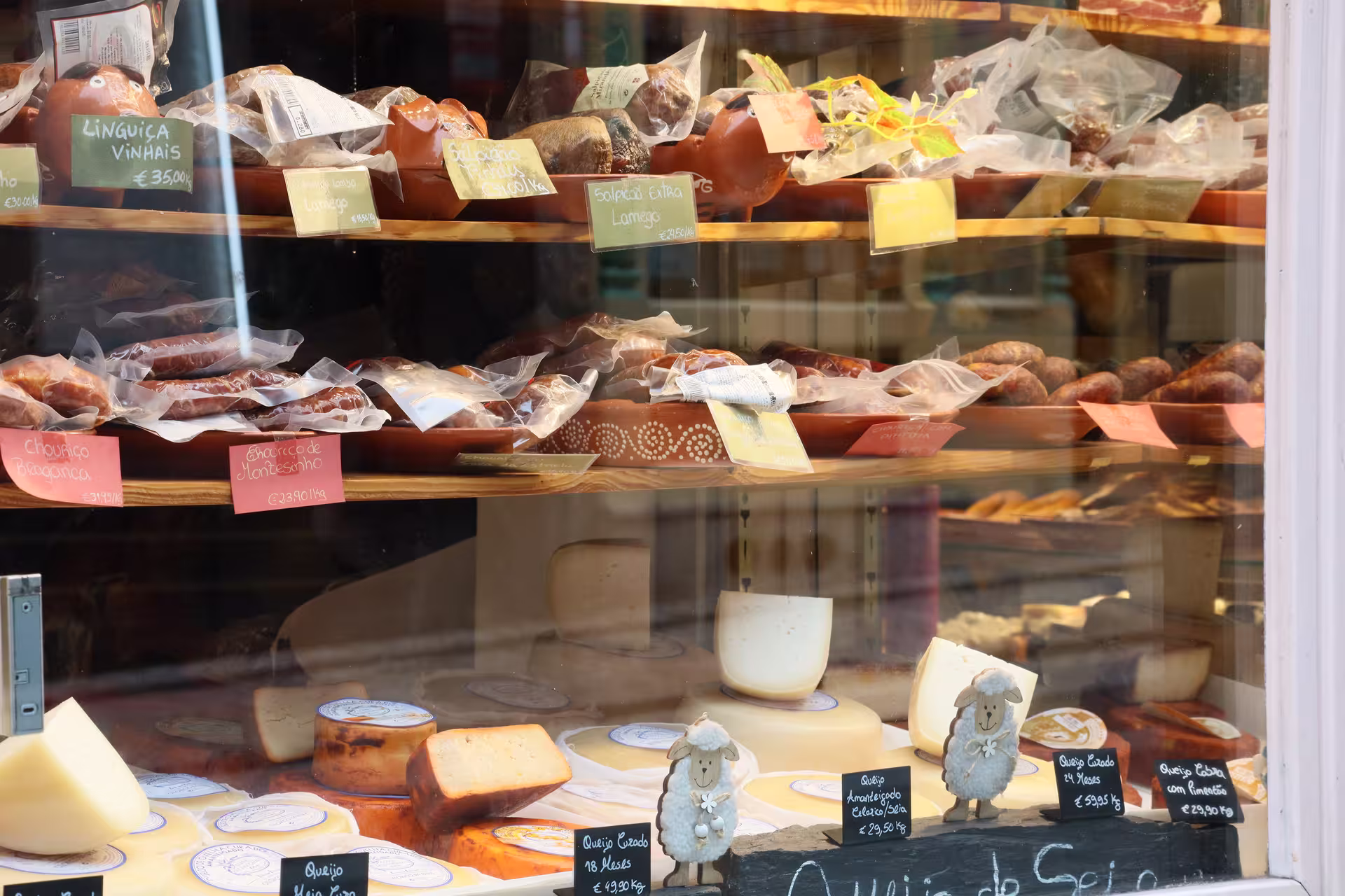 Explore a Porto deli showcasing a variety of traditional Portuguese cheeses and cured sausages on a private food tour.