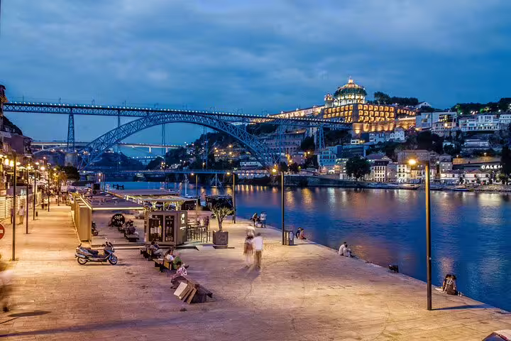 Scenic evening view of Porto's Dom Luís I Bridge and Douro River from a Lisbon private tour.