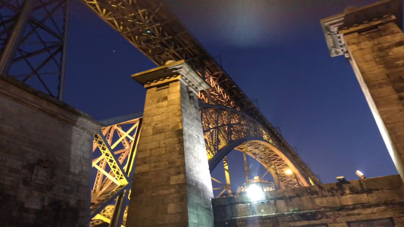 Night view of Porto's iconic Dom Luís I Bridge illuminated, highlighting its architectural beauty during a private city tour.