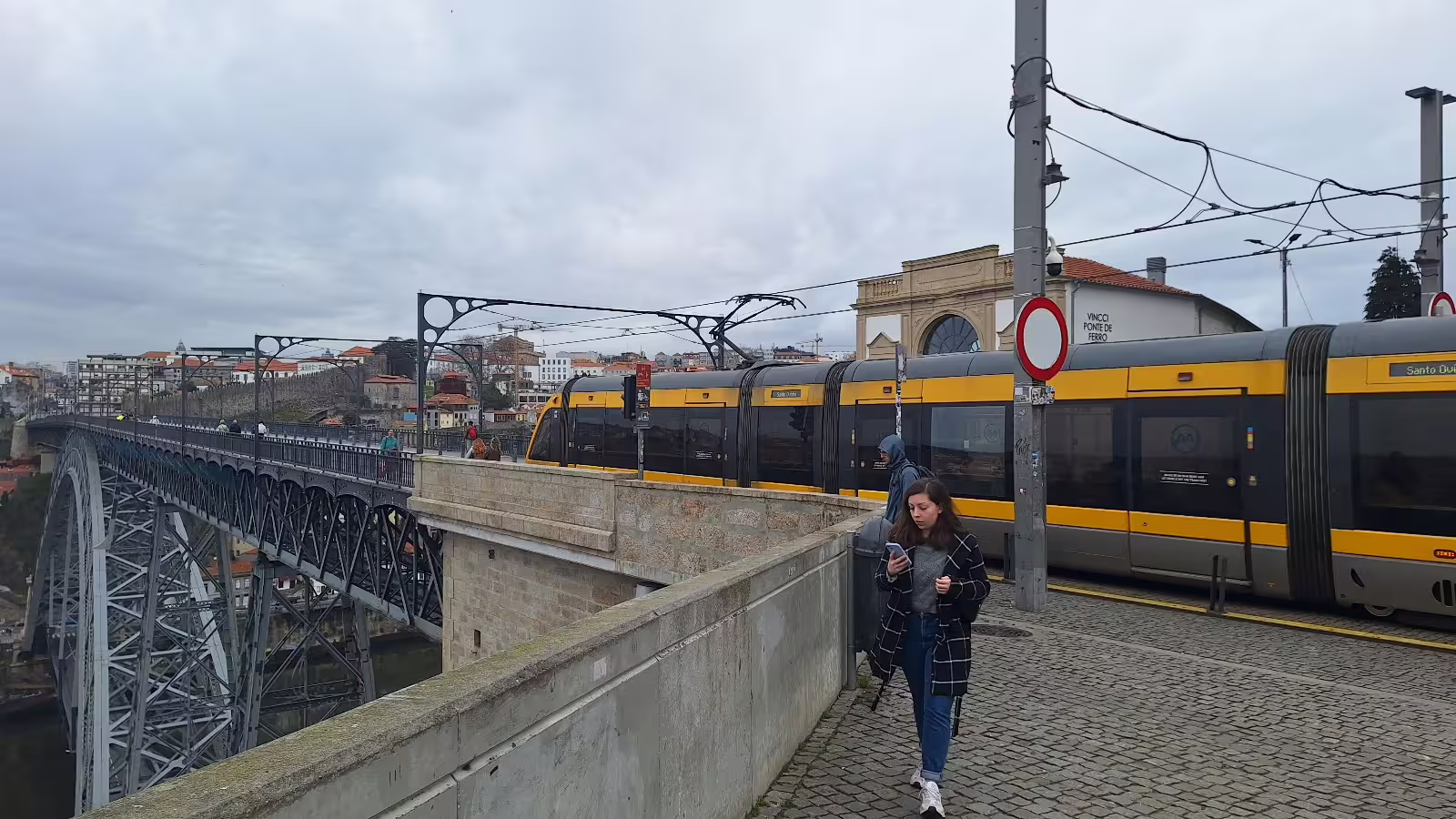 Modern tram crossing Porto's iconic Dom Luís I Bridge, capturing scenic views and local life on a private morning tour.