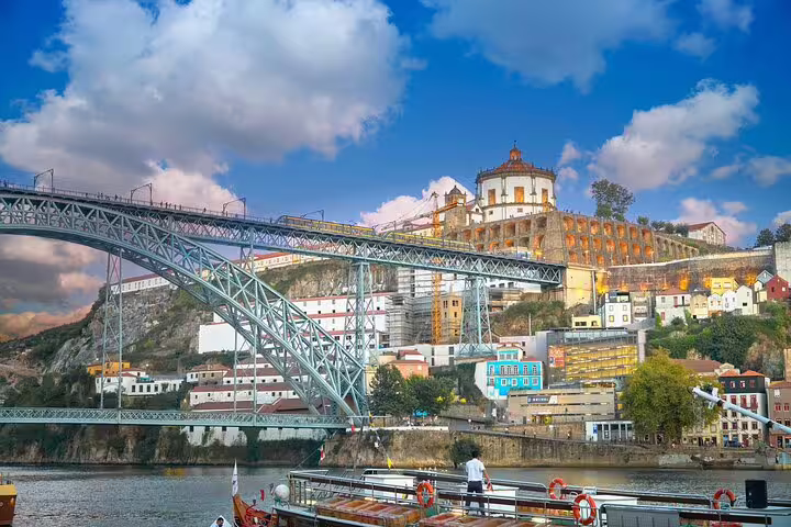 Scenic view of Porto's iconic Dom Luís I Bridge and colorful Ribeira district, perfect for a private half-day TukTuk tour.