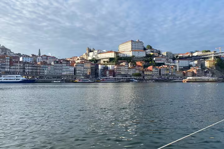Scenic view of Porto's historic Ribeira district from a Douro River boat tour, featuring charming architecture under a clear sky.