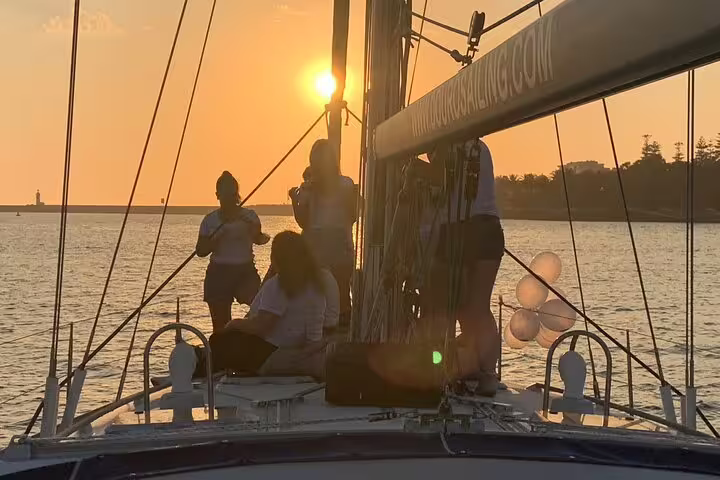 People enjoying a scenic Douro River boat tour in Porto at sunset, with wine and snacks included for a relaxing experience.