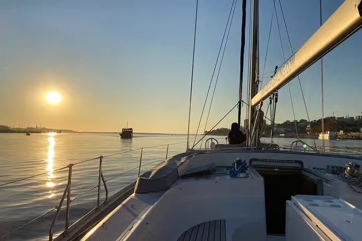 Sail along the Douro River at sunset in Porto, enjoying a boat tour with wine and snacks, capturing stunning waterfront views.