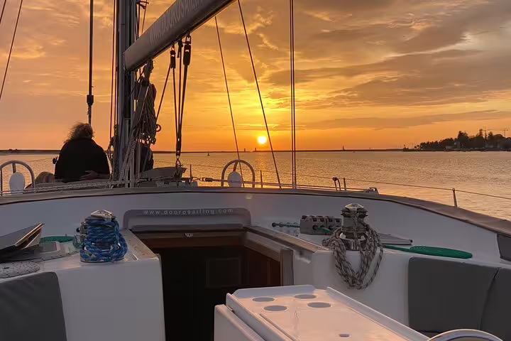 Scenic sunset view from a boat deck on the Douro River in Porto, featuring a relaxing wine and snack experience.