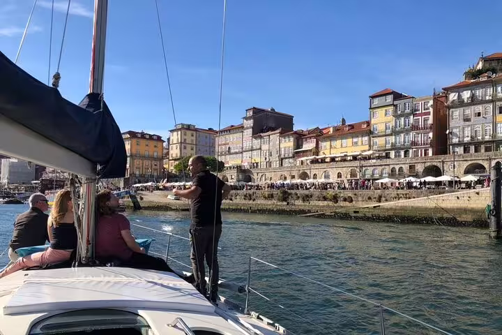 Tourists enjoy a scenic private boat tour on the Douro River, with historic Porto buildings in the background.