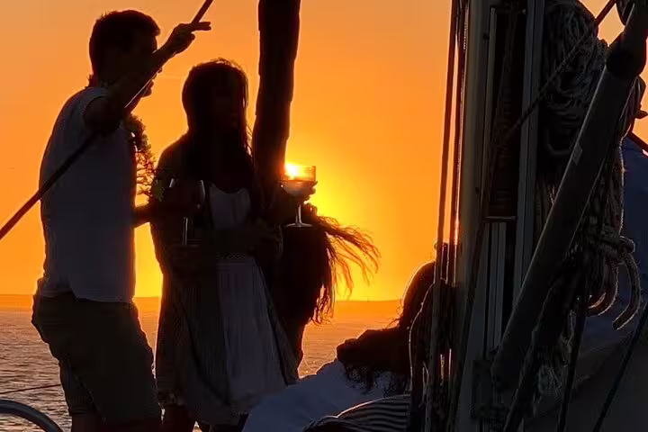 People enjoying a sunset boat tour on the Douro River in Porto, with wine and snacks, creating a perfect romantic experience.