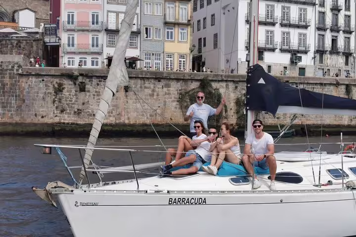 Group enjoying a sunny day on a sailboat named Barracuda on the Douro River, perfect for private sunset tours.