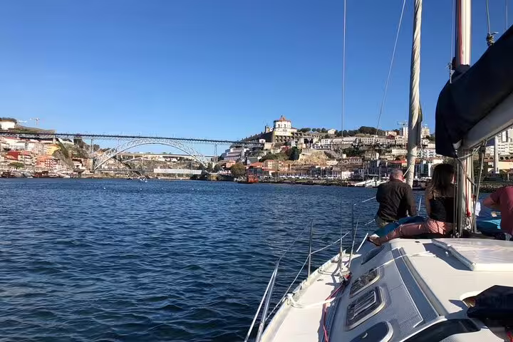 Tourists enjoy a scenic sail on the Douro River with views of Porto's historic architecture and iconic bridges.