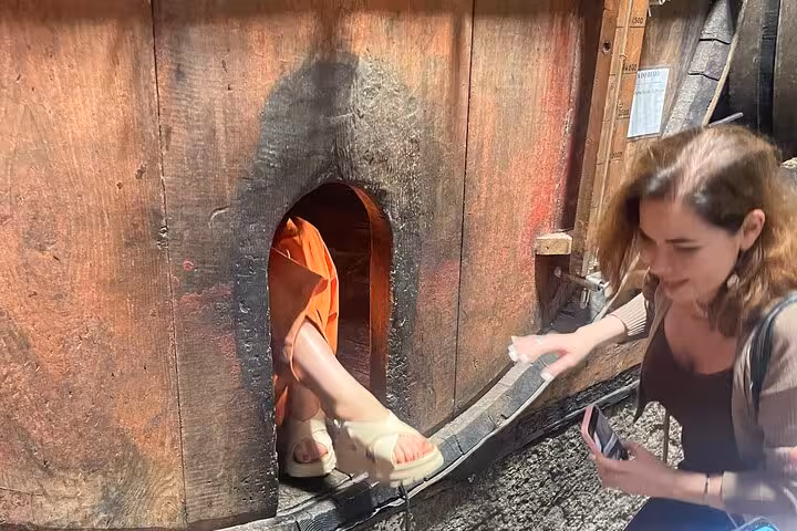 Visitor climbing out of historic wine barrel at Douro Valley estate during Porto tour with sommelier, tastings and lunch