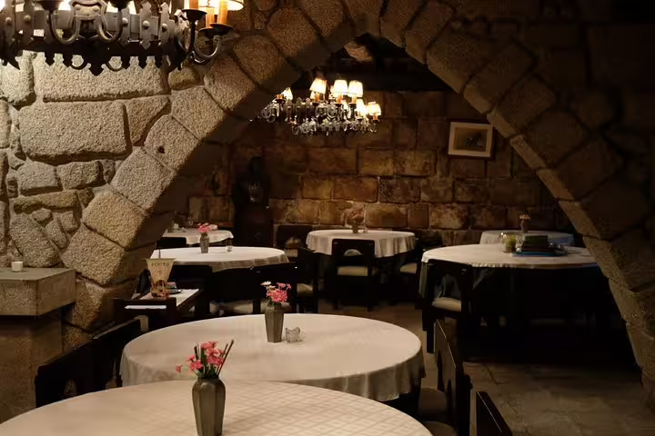 Cozy Porto restaurant interior with stone arches and ambient lighting, perfect for an intimate Fado dinner experience.