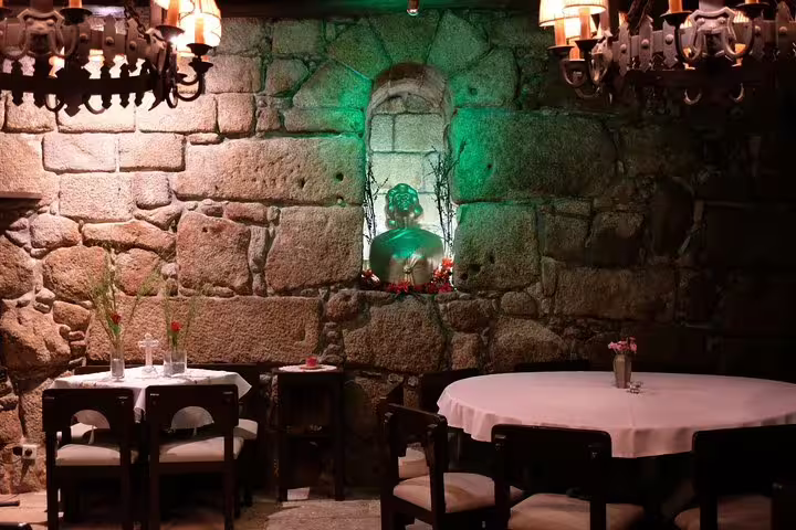 Cozy traditional Portuguese restaurant in Porto with rustic stone walls and intimate lighting, perfect for a Fado dinner experience.