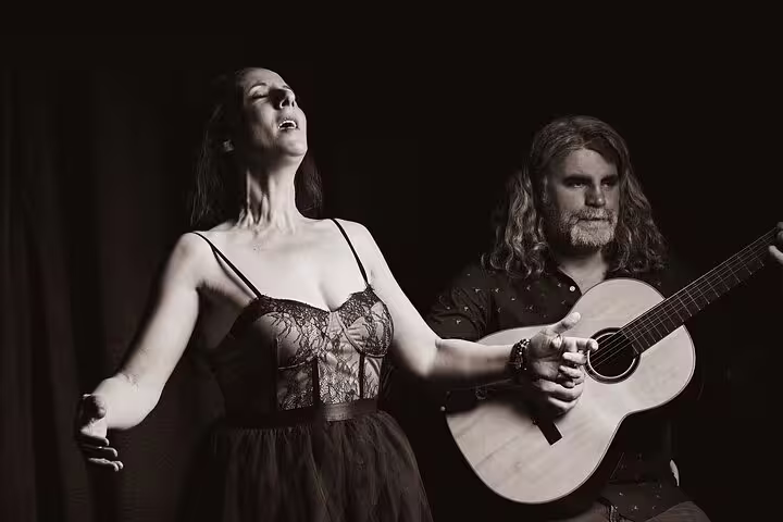 A passionate fado singer and guitarist perform intimately by Porto's scenic riverfront, capturing authentic Portuguese culture.