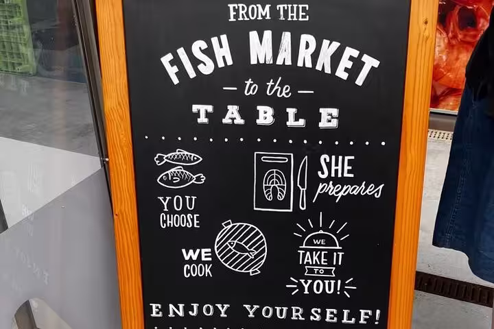 Chalkboard sign detailing the process from Porto fish market selection to table preparation for a local dining experience.