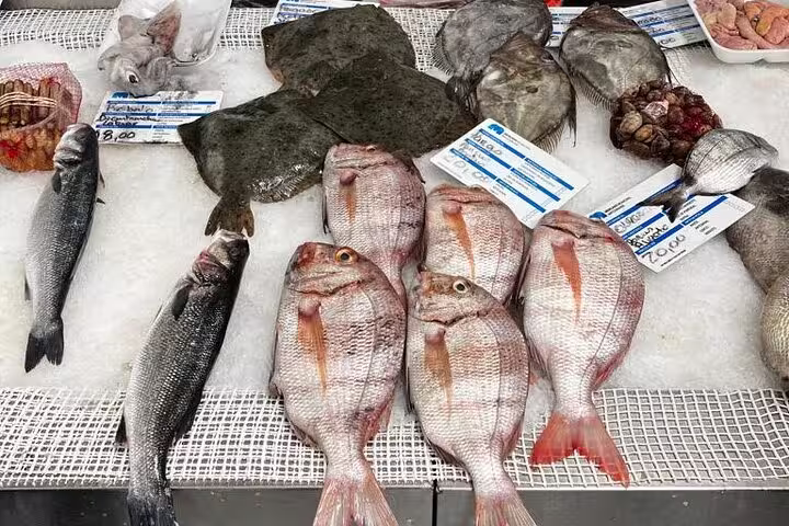 Freshly caught fish displayed on ice at Porto's local fish market, showcasing diverse seafood options for tour participants.
