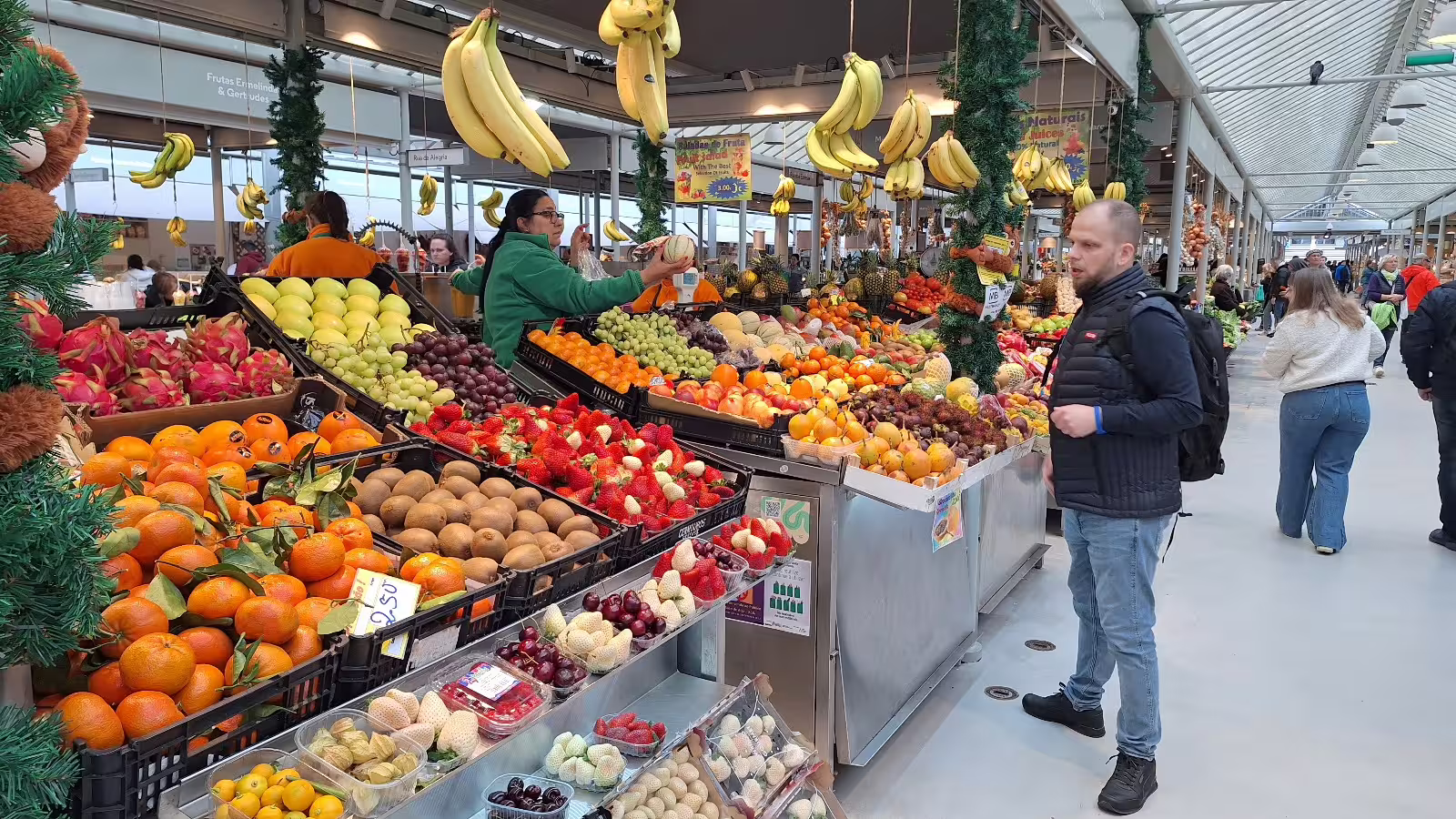 Vibrant fruit market scene in Porto, showcasing colorful produce and local interaction, perfect for a private morning tour experience.
