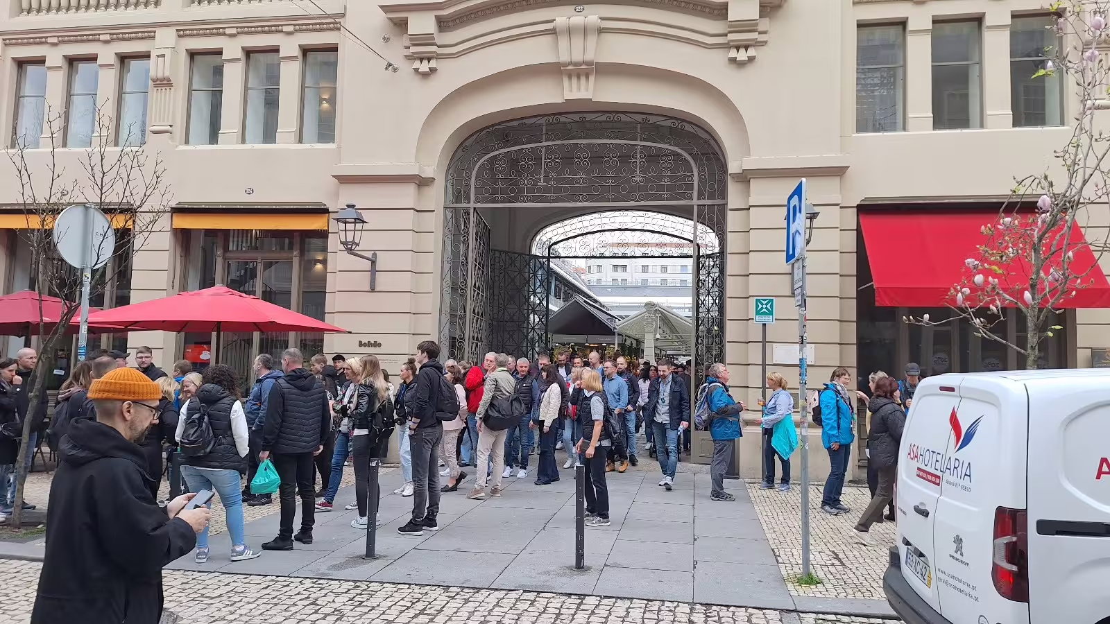 A group of tourists gathers outside a historic building in Porto, ready for a guided morning tour of the city.
