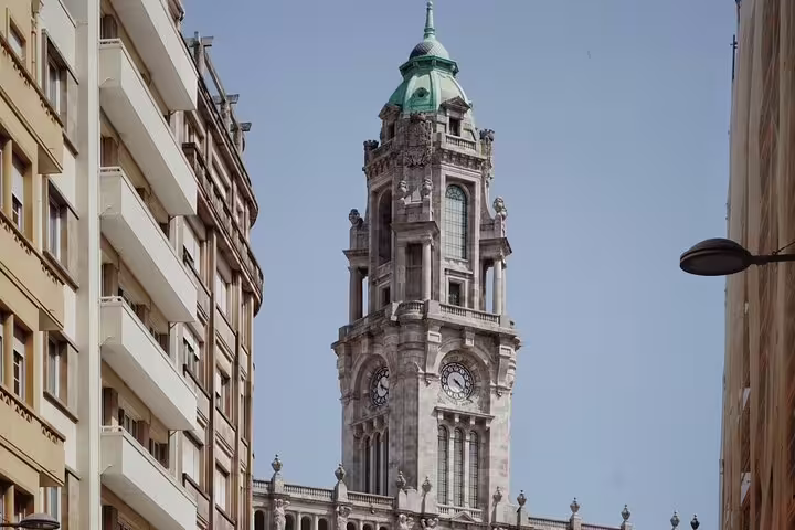Explore Porto's iconic architecture, including the majestic clock tower, on a guided tuk tuk tour through vibrant city streets.