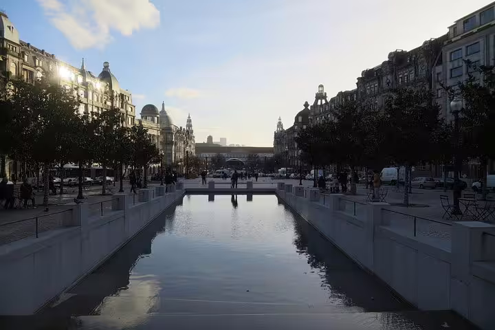 Tranquil Porto street view with a reflecting pool at dusk, surrounded by historic architecture, ideal for scenic wine tours.