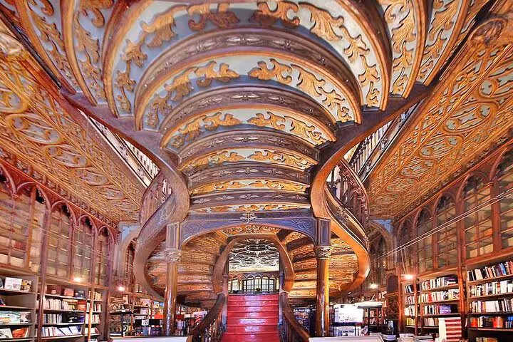 Lavish interior of a historic Porto bookstore with ornate staircases, featured on a private tour from Lisbon.