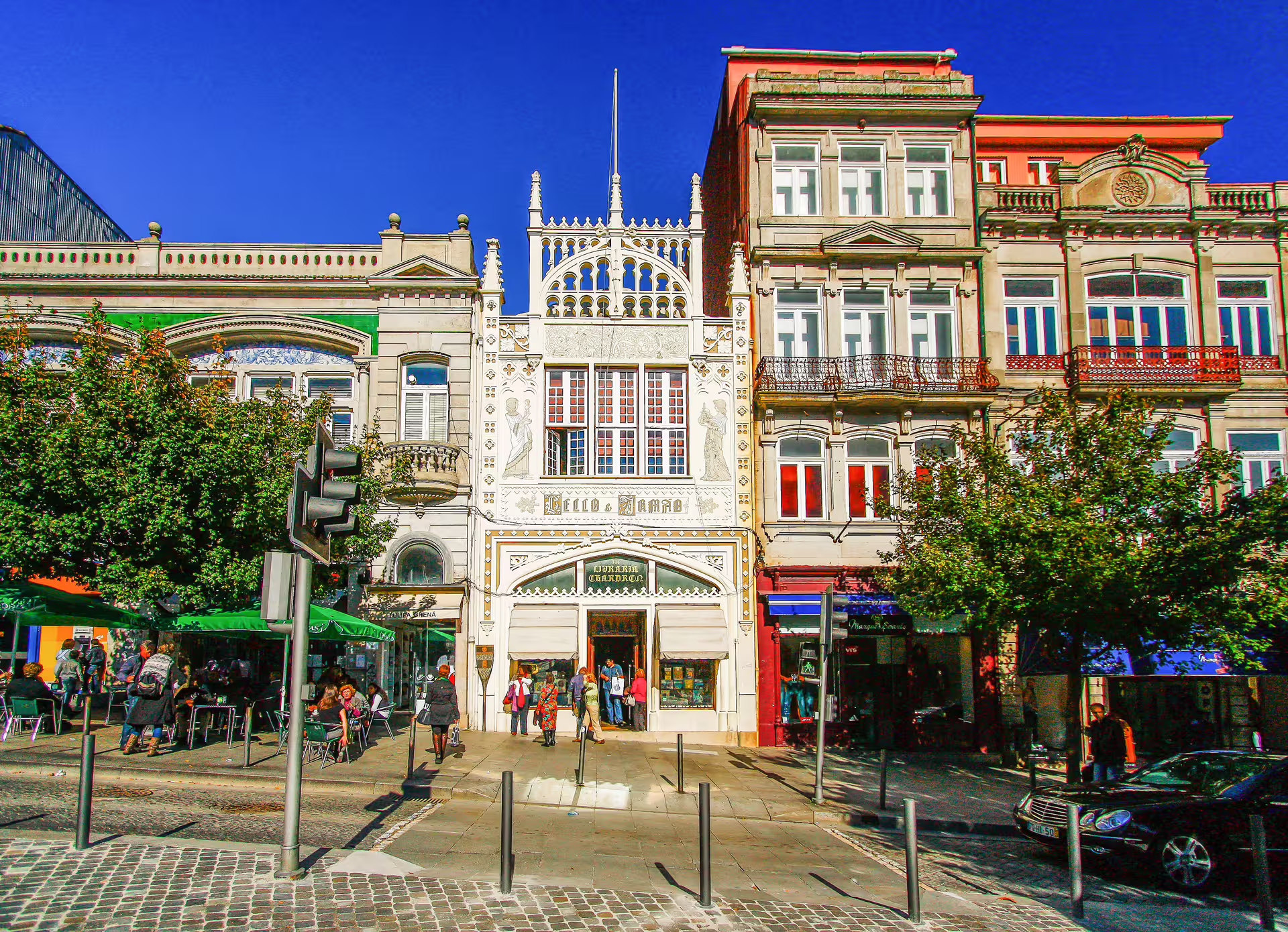 Charming street view of Porto with historic architecture and bustling cafes, perfect for a half-day city tour.